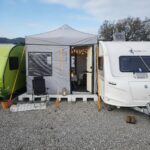 Karavana entegre edilebilen modüler kamp çadırı, fermuarlı kapı ve şeffaf pencere detaylarıyla konforlu bir dış mekân alanı oluşturur. Uzun süreli kamp ve karavan kullanımı için tasarlanmıştır.