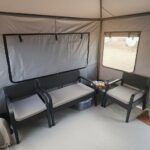 Karavan ön tente çadırının iç yaşam alanı, oturma grubu ve geniş hacmiyle rahat bir kamp deneyimi sunar. İzole taban ve kapalı yan paneller sayesinde dört mevsim kullanıma uygundur.
